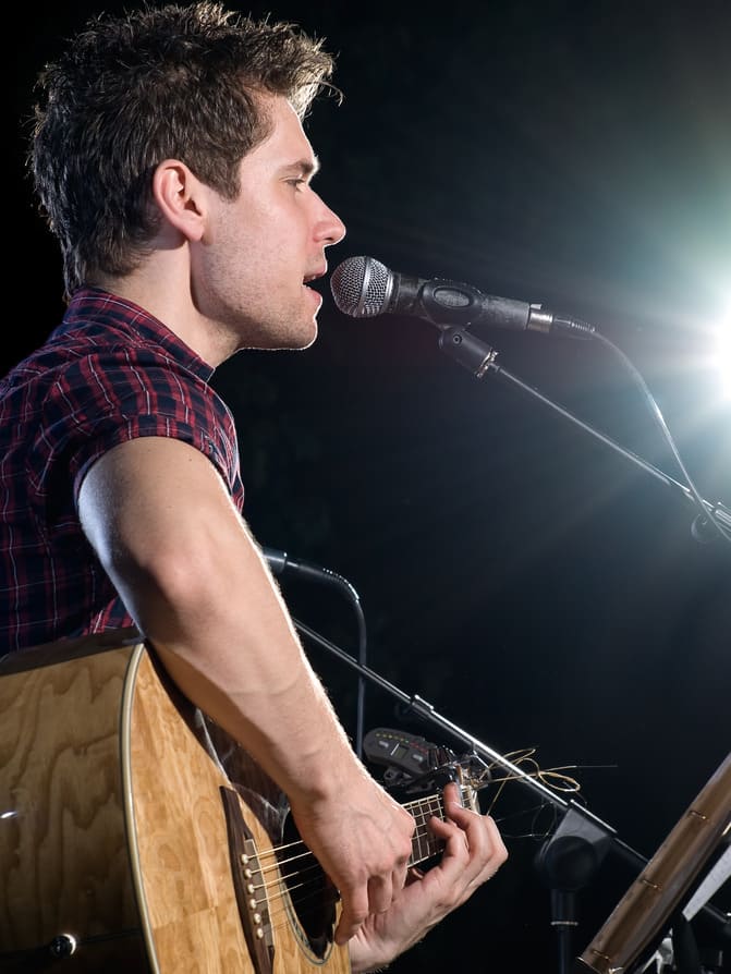 Man siniging and playing acoustic guitar